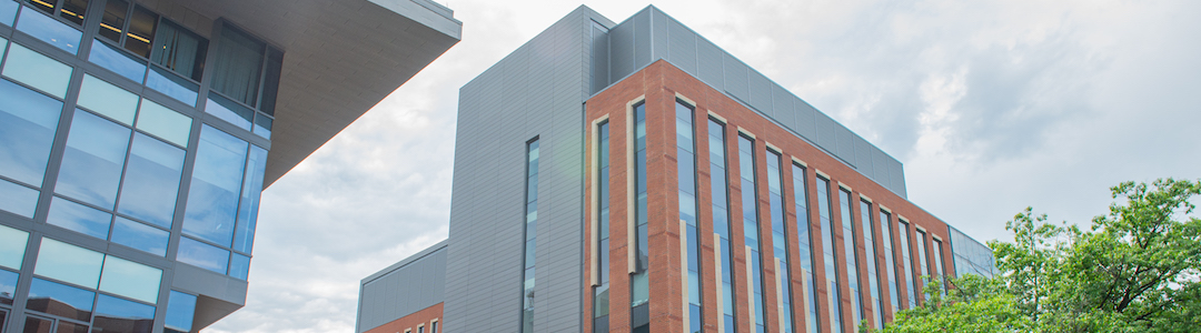 wide image of new building with partly cloudy sky