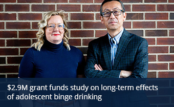 From left, Nikki Crowley and Nanyin Zhang pose for a photo in front of a red brick wall
