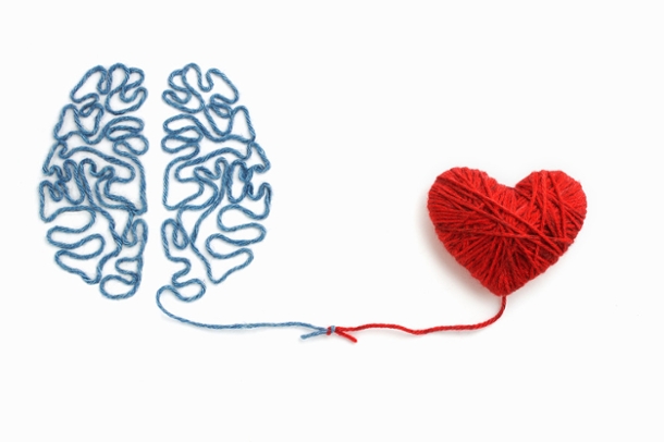 A heart made of yarn connected to a brain made of yarn