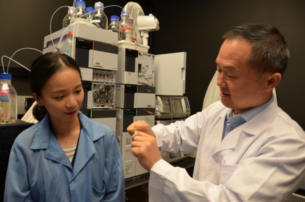 Jian Yang and student displaying bendable citrate-based material while in their lab.