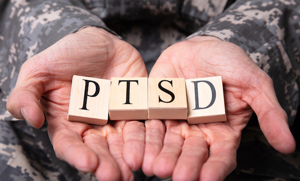PTSD spelled out in Scrabble blocks and held in a soldier's hand