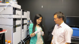 Imaging showing Dr Jian talking with student holding vial.