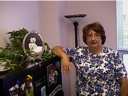 Rita Kline standing with a photo of her prize dogs.