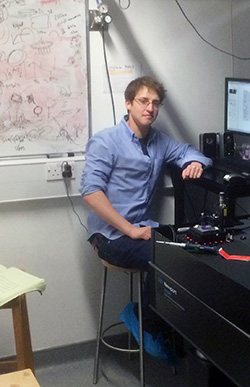 Keith Mickolajczyk sitting in front of an experiment